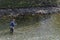 A man practices fishing inside the river