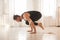 A man practices yoga in a bright studio. Man and yoga asanas with elastic