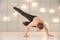 A man practices yoga in a bright studio. Man and yoga asanas with elastic