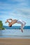 Man practicing capoeira on the beach. The man does the fighting element of capoeira.