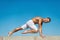 Man practicing yoga blue sky background. Reached peace of mind. Meditation and yoga concept. Yoga helps find balance