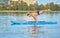 Man practicing yoga, doing balance body weight smimming on paddle board.