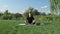 Man practicing yoga, meditating in park, sitting in lotus pose on yoga mat. Zen concept. Young tranquil male doing yoga exercises