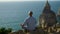 Man practicing yoga relaxation at ocean cliff edge. Carefree guy meditating in