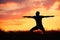 Man is practicing yoga during sunset