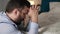 Man is praying. Bearded guy in bedroom in evening with his hands on bed saying prayer