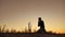 Man praying kneeling reads a praying believes in god. Faith concept. Man kneeling silhouette while hill nature sunset