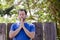 Man praying outside in front of a wooden fence.