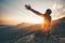 Man praying at sunset mountains raised hands