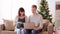 Man and pregnant wife shopping online at christmas