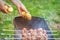 Man prepares barbecue meat with potatoes