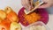 A man prepares bell peppers stuffed with minced meat and rice. Chops carrots on a grater. Close-up shot