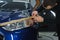 Man prepares car headlights for polishing