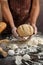 Man preparing buns at table in bakery, Man sprinkling flour over