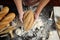 Man preparing buns at table in bakery, Man sprinkling flour over