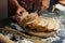 Man preparing buns at table in bakery, Man sprinkling flour over