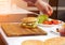 A man is preparing a fast food hamburger in a modern kitchen, cheeseburger, close-up