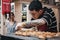 Man preparing fresh pastries at Spitalfields Market, London, UK.