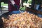 Man preparing meal in huge pan. One-pan food probably Paella. Male hand stirring ingredients. Celebration, party