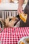 man preparing thanksgiving dinner at home kitchen, giving a dog a piece of pumpkin pie to try