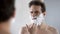 Man preparing to shave, feeling discomfort and tingle on face from shaving foam