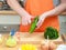 Man preparing vegetables salad peeling cucumber