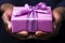 A man presenting a beautifully adorned pink gift box with a pretty bow