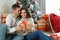 Man presenting Christmas gift to his girlfriend at home