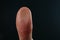 Man pressing control glass of biometric fingerprint scanner on dark background, closeup.