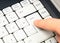 Man pressing the enter key on a simple plain white laptop keyboard, finger closeup, detail, hand up close. Decision confirmation