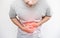 A man pressing his stomach, with red highlight of stomach pain and others stomach disease concept, on white background