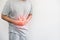 A man pressing his stomach, with red highlight of stomach pain and others stomach disease concept, on white background with copy s