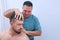 Man on preventive examination of doctor chiropractor on neck diagnostic.