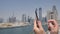 A man prints a message on the phone in the background of the panorama of Dubai. Hand close-up.