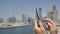 A man prints a message on the phone in the background of the panorama of Dubai. Hand close-up.