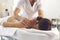 Man professional chiropractor or masseur making massage of back and shoulders for woman in clinic