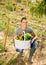 Man professional gardner holding basket with harvest of vegetables