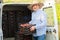 Man professional horticulturist packing crates with tasty peaches to car