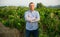 Man proffesional winemaker standing near grapes in vineyard