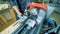 A man with prosthetic hands is working with a metal lathe in a factory equipment.