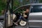 a man on a prosthetic leg sits in a car. Dressed in black jeans and a T-shirt