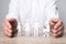 Man protecting figures of family at wooden table. closeup. Insurance concept