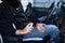 Man in protection mask sitting in the car, spraying hands antibacterial sanitizer spray for prevention coronavirus