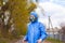 Man in protective blue overalls suit and masked respirator standing on the street, quarantine security measure, pandemic covid-19