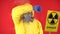 Man in protective chemical suit, protective mask with a poster Caution radiation on a red background. Radiation concept