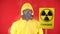 A man in a protective chemical suit, in a protective mask with a poster Radiation with a couple. Isolate, studio