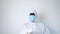 Man in protective coverall and mask dancing on a white background. Conceptual portrait of a coronavirus