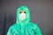 A man in a protective gauze mask and a raincoat with a hood. Simple protection against viral infection. It is on a gray background