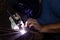 A man with protective helmet welding two pieces of metal.