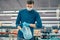 man in a protective mask buying water in a supermarket